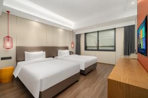 Ένα ή περισσότερα κρεβάτια σε δωμάτιο στο Kaiyuan Mingting Hotel, near Gulou Metro Station, Tianyi Square, Ningbo