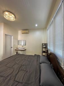 a bedroom with a large bed and a window at WANGTA Hostel in Baan Tai