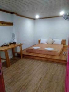 ein Schlafzimmer mit einem großen Bett und einem Schreibtisch in der Unterkunft Lalagigi Homestay in La Gi + 3 Fotos