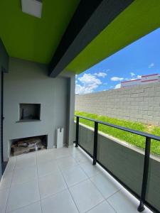 a balcony with a fireplace and a green ceiling at Apto moderno e aconchegante in Ponta Grossa