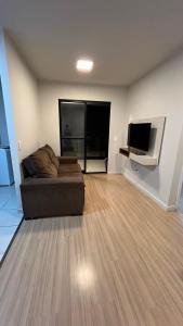 a living room with a couch and a flat screen tv at Apto moderno e aconchegante in Ponta Grossa