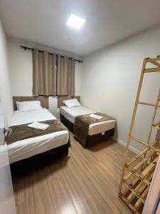 a room with two beds and a ladder in it at Apto moderno e aconchegante in Ponta Grossa