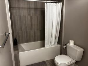 a bathroom with a tub and a toilet and a shower at Nature Home Near Downtown and 17th Avenue in Calgary +51 photos