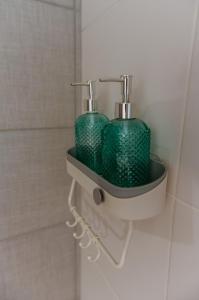 two green glass bottles in a bathroom sink at Apartamento tranquilo iluminado ideal para descansar in Montevideo
