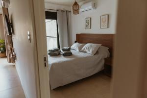 a bedroom with a bed with two hats on it at Apartamento tranquilo iluminado ideal para descansar in Montevideo