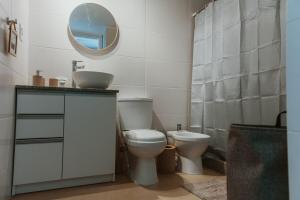 a bathroom with a toilet and a sink and a mirror at Apartamento tranquilo iluminado ideal para descansar in Montevideo