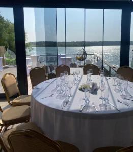a table with wine glasses and a boat in the water at Casa Rustica Cernica in Cernica