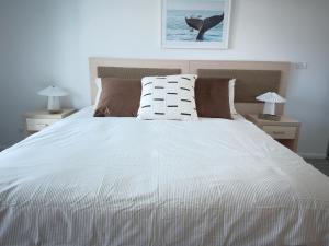 a bedroom with a large white bed with two lamps at Sea Salt Escape - 2 BEDROOMS - Oaks Port Stephens Pacific Blue Resort in Salamander Bay +41 photos