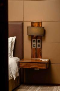 a side table with a lamp on it next to a bed at Crowne Plaza Kunming City Centre by IHG in Kunming