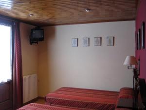 a bedroom with a bed and a tv on the wall at Casa La Abadía in Cerler