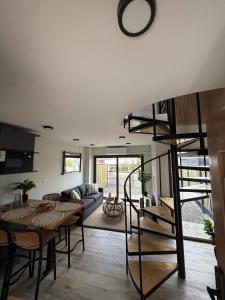 a living room with a table and a spiral staircase at Wifi, Parking, AC, Bien equipado, 5 min del centro y todo cerca in Osorno