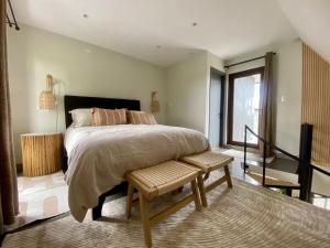 a bedroom with a bed with a bench and a window at Wifi, Parking, AC, Bien equipado, 5 min del centro y todo cerca in Osorno