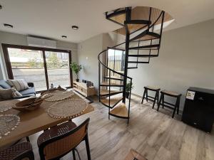 a living room with a spiral staircase and a table at Wifi, Parking, AC, Bien equipado, 5 min del centro y todo cerca in Osorno +16 photos