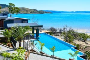 a large swimming pool next to a beach at Hidden Cove on Hamilton Island by HIHA in Hamilton Island