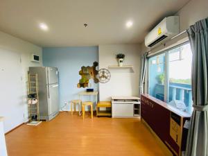 een keuken met een koelkast en een tafel met stoelen bij LPN Seaview Cha-am in Ban Phu Wai