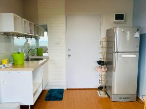 een keuken met een koelkast en een wastafel bij LPN Seaview Cha-am in Ban Phu Wai +5 foto's