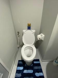 een kleine badkamer met een toilet en een blauw tapijt bij LPN Seaview Cha-am in Ban Phu Wai