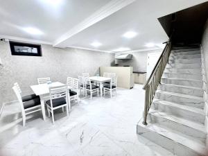 ein Esszimmer mit Tisch und Stühlen und Treppe in der Unterkunft Sunnat guest house in Buxoro