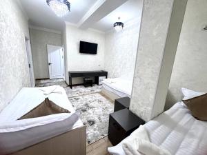 ein Schlafzimmer mit zwei Betten und einem Klavier in der Unterkunft Sunnat guest house in Buxoro