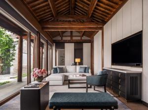 a living room with a couch and a tv at Mandarin Oriental Qianmen, Beijing in Beijing