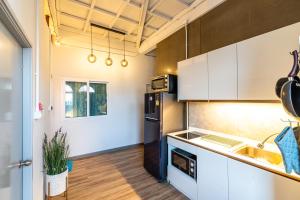 a kitchen with white cabinets and a black refrigerator at Queen On Street 2009 in Ban Lo Long