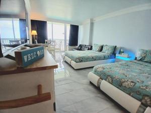 ein Hotelzimmer mit zwei Betten und einem Tisch in der Unterkunft Amazing Ocean View Beachfront Entire Apartment Direct access to Beach in Daytona Beach