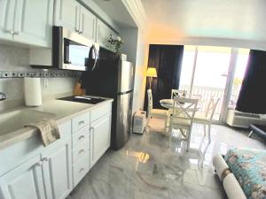 eine Küche mit einem Kühlschrank sowie einem Tisch und Stühlen in der Unterkunft Amazing Ocean View Beachfront Entire Apartment Direct access to Beach in Daytona Beach + 33 Fotos