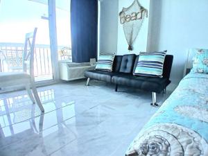 ein Schlafzimmer mit einem Bett und einem Stuhl und einem Balkon in der Unterkunft Amazing Ocean View Beachfront Entire Apartment Direct access to Beach in Daytona Beach