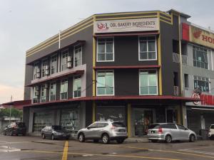 a building with cars parked in a parking lot at BENUTHOMEStay in Benut