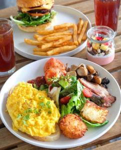 Una mesa con dos platos de desayuno con un sándwich y papas fritas. en Starlight Hotel25, en Ho Chi Minh