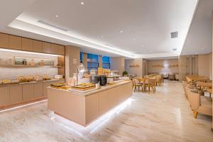 a restaurant with a cafeteria with tables and chairs at JI Hotel Chengdu High Tech in Chengdu