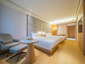 una grande camera d'albergo con un grande letto e una sedia di JI Hotel Chengdu Tianfu Square a Chengdu