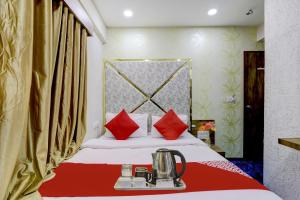 ein Hotelzimmer mit einem Bett mit roten Kissen in der Unterkunft Hotel O Bhavy in Ahmedabad