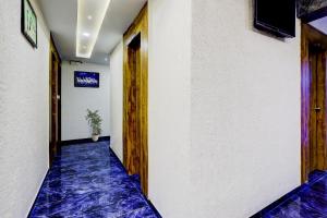 einen Flur mit blauem Teppichboden in einem Gebäude in der Unterkunft Hotel O Bhavy in Ahmedabad