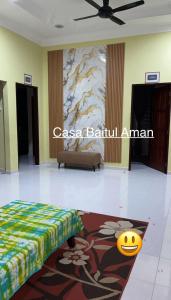 a room with a bed and a painting on the wall at Casa Baitul Aman in Kuala Terengganu