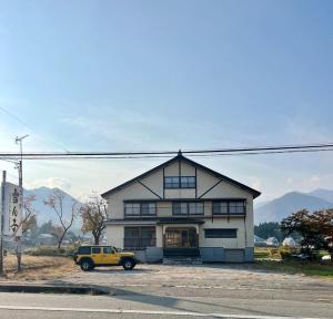a yellow truck parked in front of a house at ロッヂ 雪ん子 in Yuzawa +4 photos