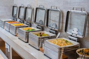 una fila di vassoi di cibo su un bancone di JI Hotel Chengdu Tianfu Square a Chengdu