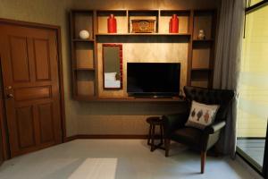 a living room with a chair and a television at BaanPranwadee in Nong Khai