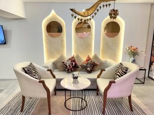 ein Wohnzimmer mit einer Couch und zwei Sesseln in der Unterkunft Studio F Sukhumvit in Bangkok + 31 Fotos