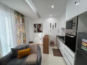 a living room with a couch and a kitchen at Apartamento Batuku in Praia