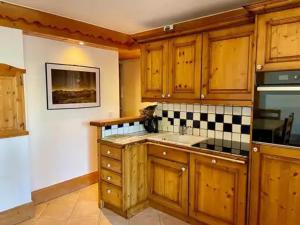 a kitchen with wooden cabinets and a sink at Appartement à Méribel 4 pers, piscine, skis aux pieds - FR-1-411-1007 in Chandon
