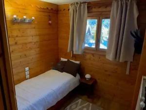 a bedroom with a bed and a window at Appartement à Méribel 4 pers, piscine, skis aux pieds - FR-1-411-1007 in Chandon