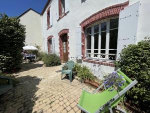 a patio of a house with chairs and a table at Maison familiale charme 8 pers, St-Gildas de Rhuys, jardin clos - FR-1-775-56 in Saint-Gildas-de-Rhuys