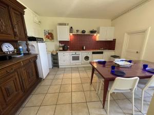 a kitchen with a wooden table and white appliances at Maison familiale charme 8 pers, St-Gildas de Rhuys, jardin clos - FR-1-775-56 in Saint-Gildas-de-Rhuys +15 photos