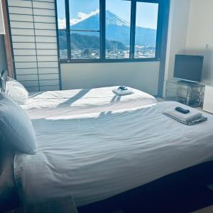 a white bed with a view of a mountain at ホテル富士山水館富士山一望河口湖車で3分 in Fujikawaguchiko +24 photos