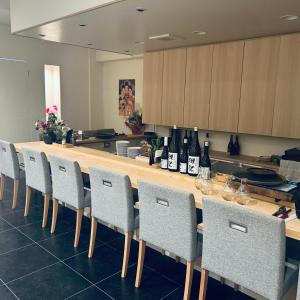 a kitchen with a bar with chairs and bottles of wine at ホテル富士山水館富士山一望河口湖車で3分 in Fujikawaguchiko