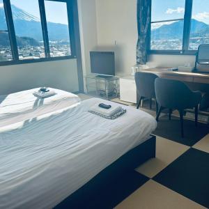 a hotel room with a bed and a desk with a computer at ホテル富士山水館富士山一望河口湖車で3分 in Fujikawaguchiko