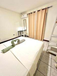 a bedroom with a white bed in a room at Casa Maya Guesthouse in Mal País
