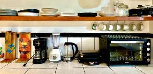 a kitchen counter with a toaster oven and other appliances at Casa Maya Guesthouse in Mal País