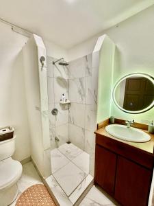a bathroom with a sink and a shower and a toilet at Casa Maya Guesthouse in Mal País